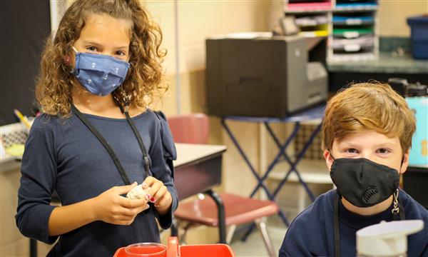 Two students smile
